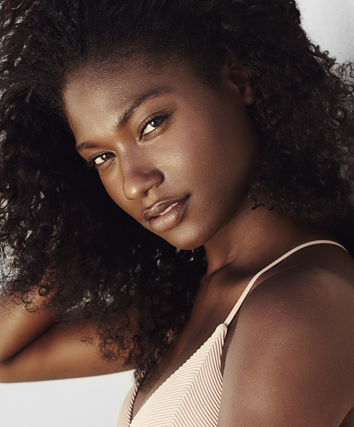Portrait of a confident woman with curly hair.