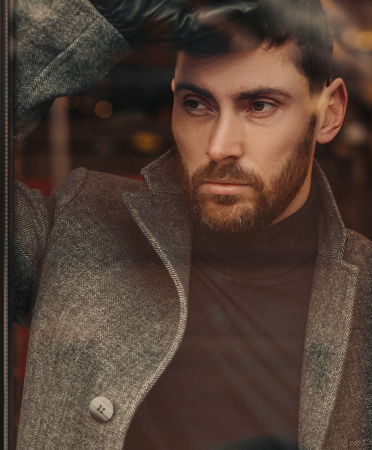 Man looking thoughtfully through a window.
